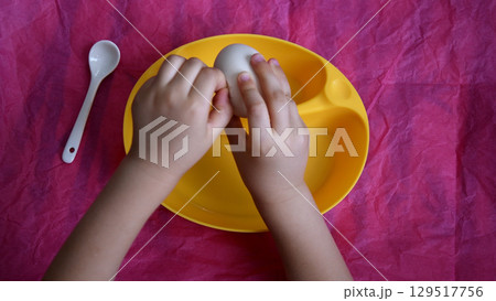 Directly above view of toddler hands peeling eggshell Directly above view of toddler hands peeling eggshell 129517756