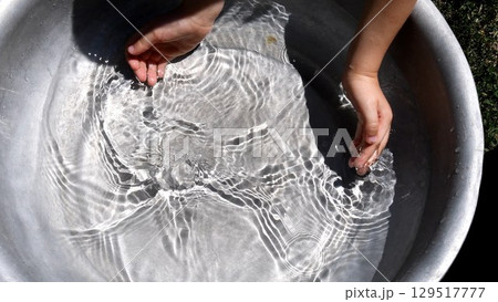Toddler hands trying to collect clear water in handful playing water games Toddler hands trying to collect clear water in handful playing water games 129517777