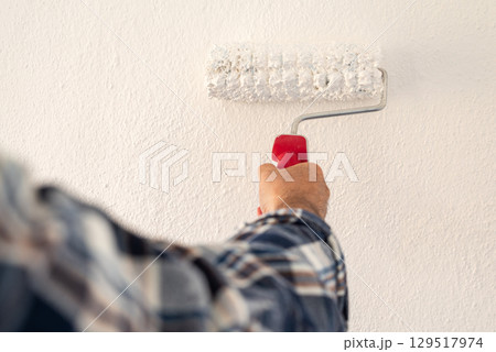 House painter worker painting a wall white. Building. House painter worker painting a wall white. Building. 129517974