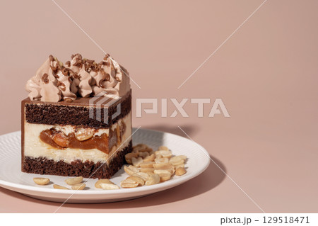 Caramel and nut bento cake with chocolate sponge layers, topped with creamy frosting, served on a white plate, perfect for dessert and pastry menu concepts with copy space 129518471