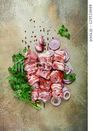 raw pork meat, on wooden skewers, pickled kebab , with spices and herbs, on the table, top view, no people, 129518694