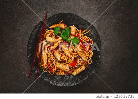 udon noodles, with squid and vegetables, on a black plate, homemade, no people, 129518733