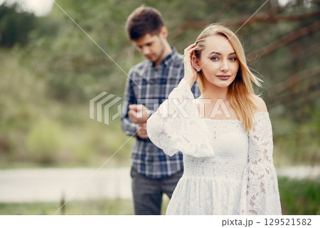 Cute couple in a park. Lady in a white dress. Guy in a blue shirt 129521582