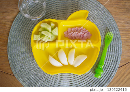 Food for kids, picky eaters, boiled eggs, ham and cucumber, yellow plastic plate Food for kids, picky eaters, boiled eggs, ham and cucumber, yellow plastic plate 129522416