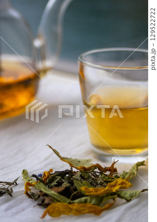 Medicinal herbs in the foreground next to an herbal infusion. Blurred background. Medicinal herbs in the foreground next to an herbal infusion. Blurred background. 129522722