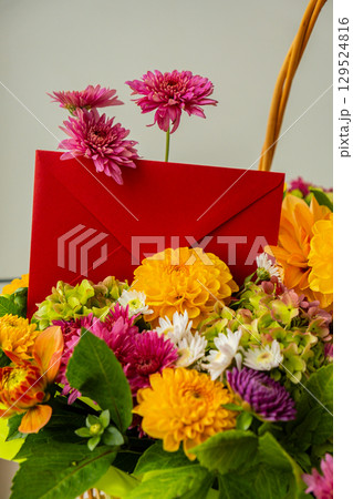 Red envelope gift present idea Flower delivery Selective focus Bush of autumnal orange red chrysanthemums and violet dahlia hydrangea. Fall garden beautiful flowers bouquet background. Blooming 129524816