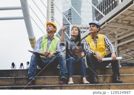 Contractor construction engineer meeting talking together on architect table at construction office site. Businessman engineer manager discuss with foreman team builder look at plan blueprint laptop Contractor construction engineer meeting talking together on architect table at construction office site. Businessman engineer manager discuss with foreman team builder look at plan blueprint laptop 129524997