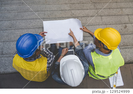 Contractor construction engineer meeting talking together on architect table at construction office site. Businessman engineer manager discuss with foreman team builder look at plan blueprint laptop Contractor construction engineer meeting talking together on architect table at construction office site. Businessman engineer manager discuss with foreman team builder look at plan blueprint laptop 129524999