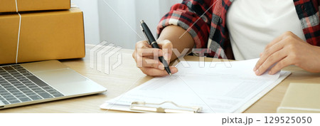 Banner Online seller Close up hands Young asian woman typing laptop keyboard checking online order on stock delivery package. Asian woman startup small business at home office with copy space Banner Online seller Close up hands Young asian woman typing laptop keyboard checking online order on stock delivery package. Asian woman startup small business at home office with copy space 129525050