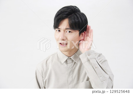 男性 耳に手を当てて聴く 20代 白背景 男性 耳に手を当てて聴く 20代 白背景 129525648