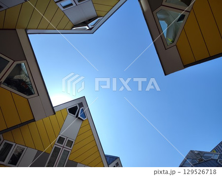 Blue sky framed by geometric rooftop shapes. Yellow Cube Houses in Rotterdam, Netherlands. Kubuswoningen, designed by Piet Blom 129526718