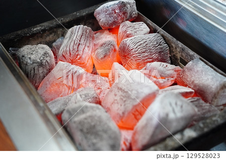 Glowing Charcoal Briquettes on Grill 129528023