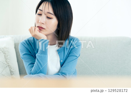 リビングで悩む若い女性 リビングで悩む若い女性 129528172