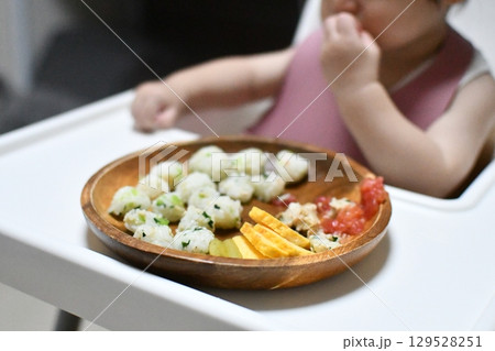離乳食後期、つかみ食べをする赤ちゃんの手 離乳食後期、つかみ食べをする赤ちゃんの手 129528251