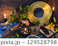 Mystic still life with magic books, tansy flowers, black candles and witchy ritual objects on old table. Occult, esoteric, gothic and wicca concept Mystic still life with magic books, tansy flowers, black candles and witchy ritual objects on old table. Occult, esoteric, gothic and wicca concept 129528798