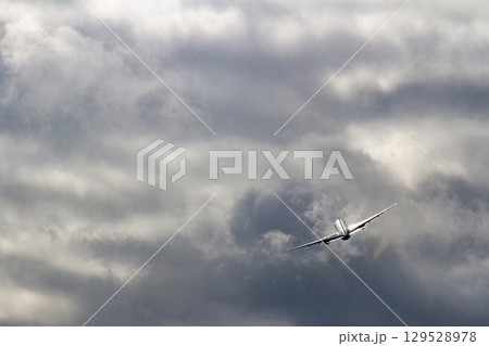曇天を上昇する飛行機シルエット 129528978