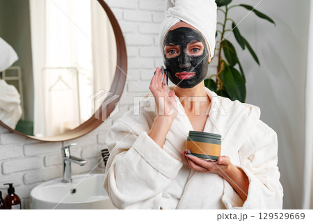 Relaxing skincare routine with face mask in modern bathroom setting during morning hours Relaxing skincare routine with face mask in modern bathroom setting during morning hours 129529669