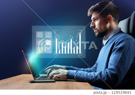 Professional working on financial analysis with data visualization on laptop in a modern office setting at night Professional working on financial analysis with data visualization on laptop in a modern office setting at night 129529691