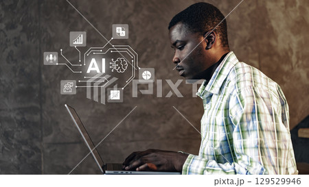 Skilled individual uses laptop to explore artificial intelligence concepts in a modern workspace setting 129529946