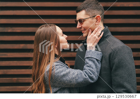 Young couple sharing a romantic moment outdoors in a city setting during a sunny day 129530667