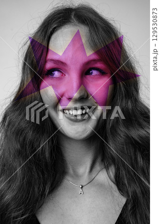 Woman with star-shaped artistic overlay smiling joyfully in studio setting Woman with star-shaped artistic overlay smiling joyfully in studio setting 129530873