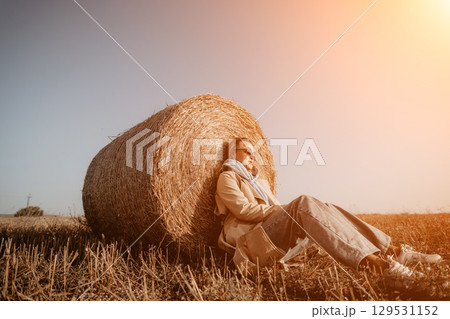 Woman Relaxing by a Hay Bale Woman Relaxing by a Hay Bale 129531152