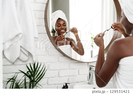 Woman applying skincare in modern bathroom with a warm and inviting atmosphere at morning time Woman applying skincare in modern bathroom with a warm and inviting atmosphere at morning time 129531421