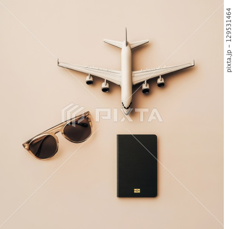 Top view of sunglasses, biometric passport and small airplane figurine 129531464