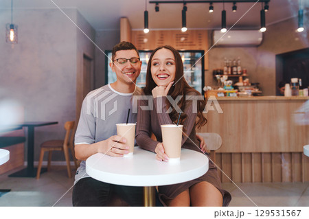 Couple enjoying coffee together in a cozy cafe on a sunny day 129531567