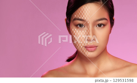 Model showcasing beauty and makeup techniques with artistic geometric design on face against a pink backdrop Model showcasing beauty and makeup techniques with artistic geometric design on face against a pink backdrop 129531598