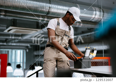 Skilled worker preparing tools in a modern workspace during the afternoon Skilled worker preparing tools in a modern workspace during the afternoon 129531607