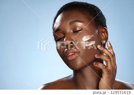 Model applying skincare product during a beauty routine in a studio with natural light, capturing the essence of self-care and wellness Model applying skincare product during a beauty routine in a studio with natural light, capturing the essence of self-care and wellness 129531619