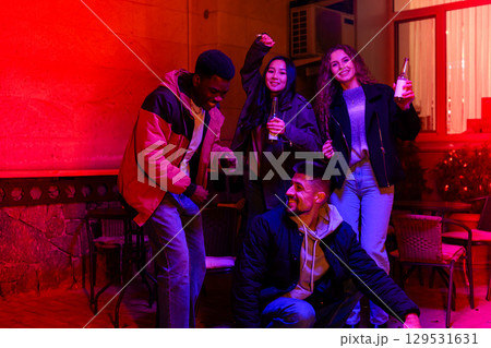 Friends enjoying a vibrant night out at a festive gathering in a lively urban setting Friends enjoying a vibrant night out at a festive gathering in a lively urban setting 129531631