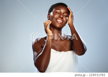 Smiling woman enjoying skincare routine with soft lighting in studio setting during morning Smiling woman enjoying skincare routine with soft lighting in studio setting during morning 129531765
