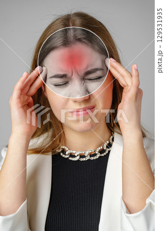 Individual experiencing headache while holding transparent overlay on forehead in studio setting Individual experiencing headache while holding transparent overlay on forehead in studio setting 129531935
