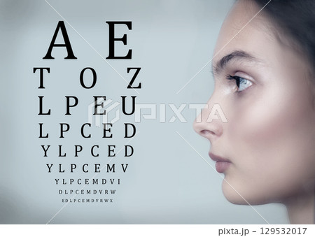 Woman undergoing an eye test with an eye chart displayed in a clinical setting during daylight hours Woman undergoing an eye test with an eye chart displayed in a clinical setting during daylight hours 129532017