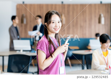 オフィスでスマホを使う若いビジネスウーマン 129532485