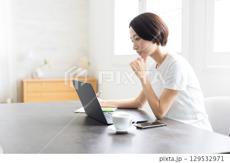 明るい自宅でノートパソコンを使ってテレワークする女性 明るい自宅でノートパソコンを使ってテレワークする女性 129532971