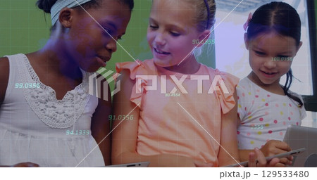 Using tablets three schoolgirls collaborating at classroom desk, with digital grid overlay Using tablets three schoolgirls collaborating at classroom desk, with digital grid overlay 129533480
