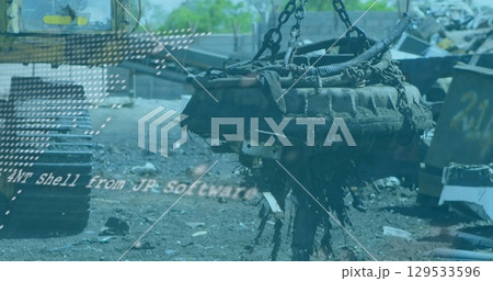 Hoisting electromagnet lifter raising corroded engine block over scrap yard, with heavy chains 129533596