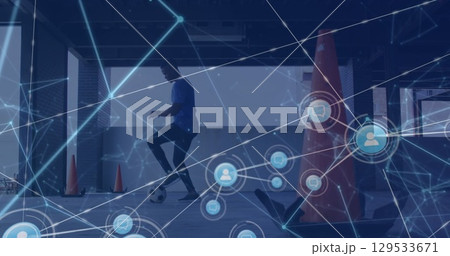 Network of digital icons against african american male soccer player practicing Network of digital icons against african american male soccer player practicing 129533671
