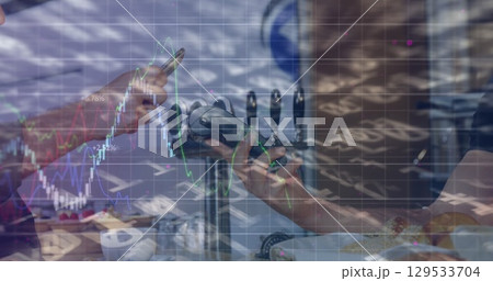 Image of graphs over hands of caucasian people using payment terminal Image of graphs over hands of caucasian people using payment terminal 129533704