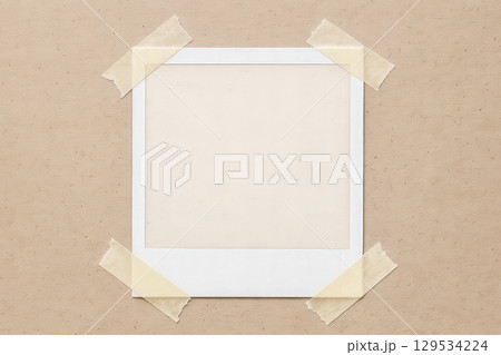 Empty vintage instant photo frame taped to cardboard background, retro picture mockup for your personal image or precious memories Empty vintage instant photo frame taped to cardboard background, retro picture mockup for your personal image or precious memories 129534224