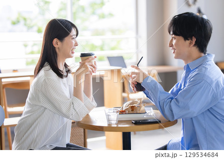 カフェでくつろぐ若い男女 129534684
