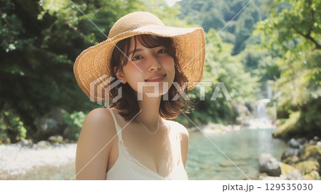 夏の渓流沿いの遊歩道に立つ若い日本人女性 129535030