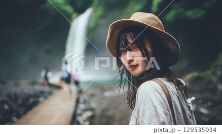 夏の渓流沿いの遊歩道に立つ若い日本人女性 129535034
