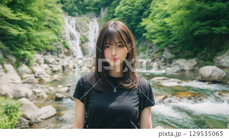 夏の渓流沿いの遊歩道に立つ若い日本人女性 129535065