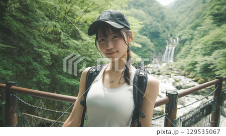 夏の渓流沿いの遊歩道に立つ若い日本人女性 129535067