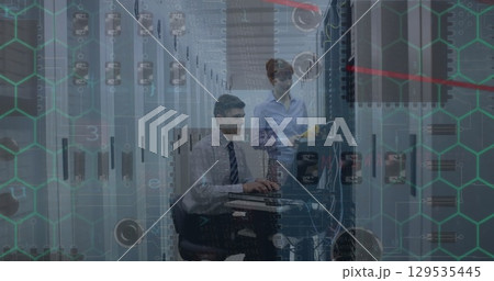 Microprocessor connections over caucasian male and female engineers working at server room 129535445