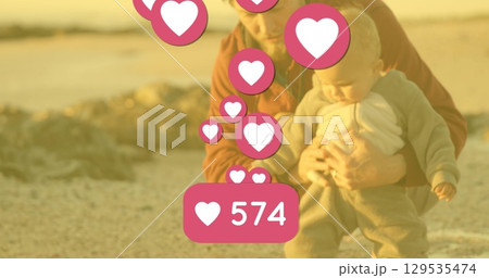 Image of falling hearts over happy caucasian happy baby with dad 129535474